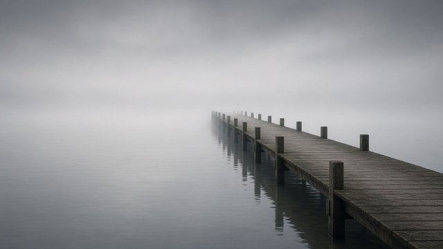 Empty wooden pier fading into thick grey fog over still water, quiet minimal mood, original AI mood wallpaper