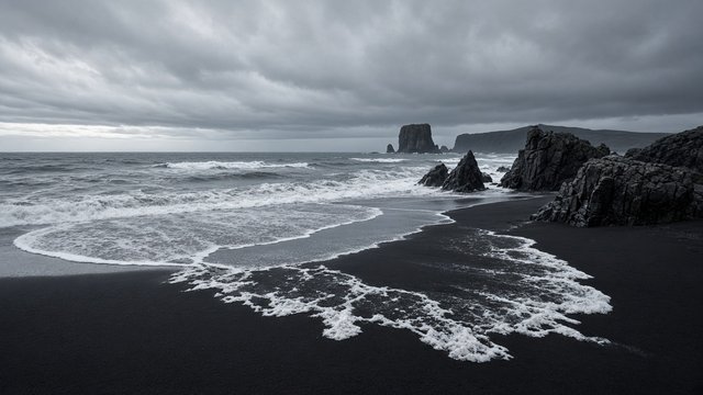 Black volcanic sand beach with white foamy waves lacing the shore, basalt rocks, overcast moody sky, minimalist seascape, original AI nature wallpaper